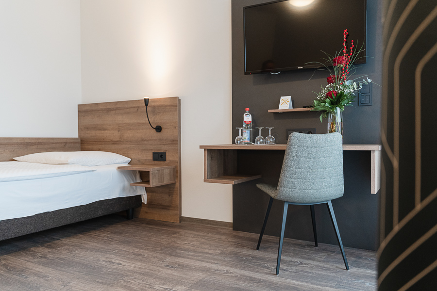 Modernes Hotelzimmer mit frischen Blumen und Sekretär Tisch im Hotel Gasthof Zum Rössle Altenstadt